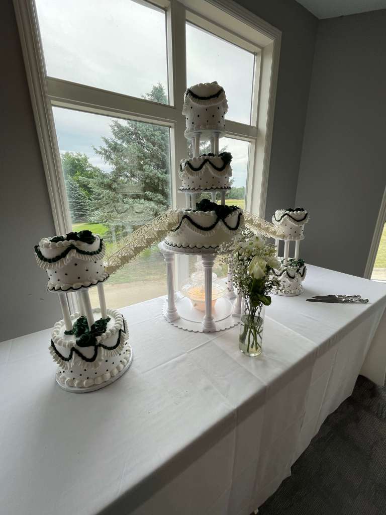 White and green accented cake on display in banquet hall